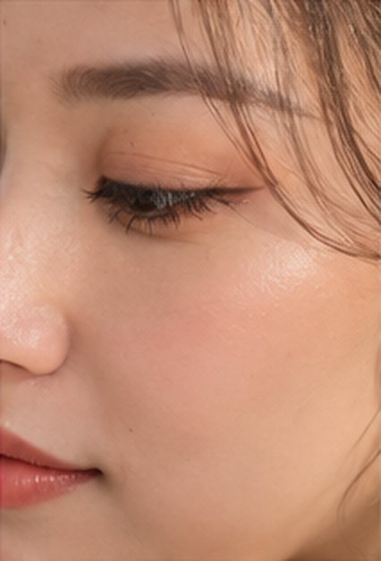 Close-up of a softly defined brow and peach eye makeup